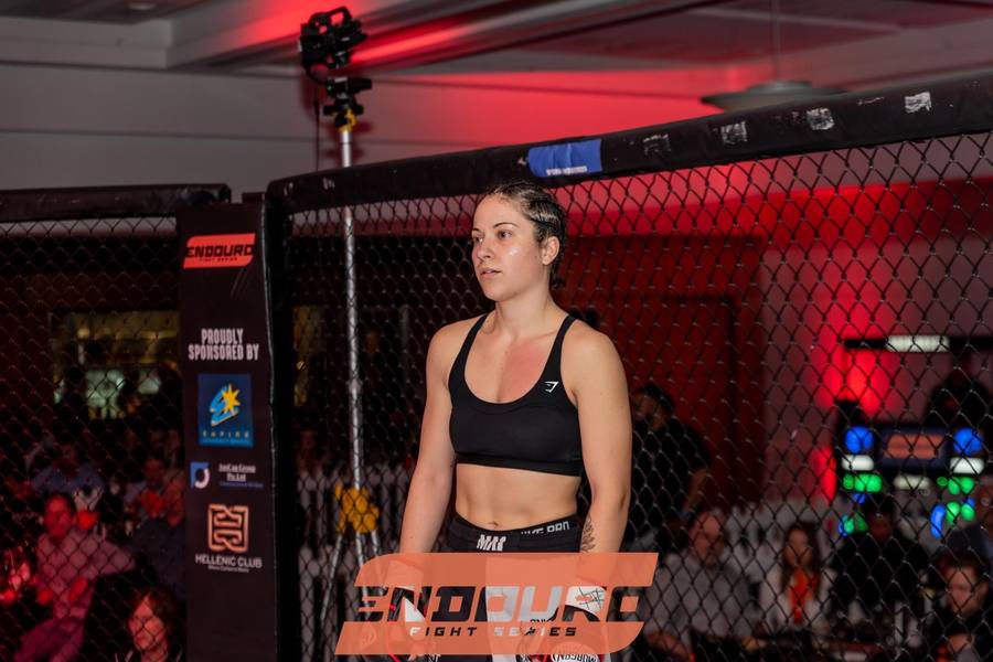 Riley Kerr's athlete Emilee Della-Libra in the cage at an amateur MMA event