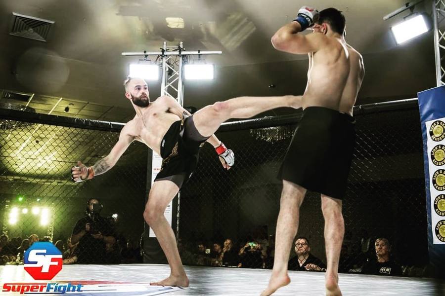 Riley Kerr's athlete Mitch Holden throwing a head kick in an MMA cage fight